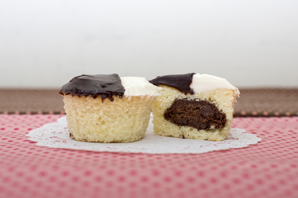 Vanilla cupcake with chocolate chocolate chip cookie inside topped with vanilla buttercream & fudge frosting