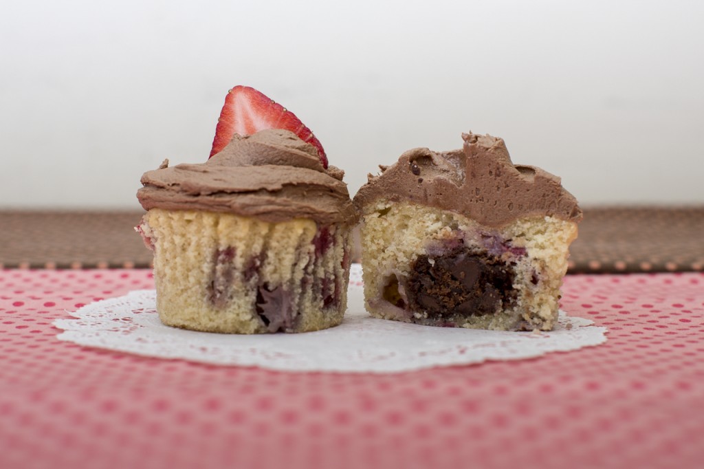 Strawberry cupcake with chocolate chocolate chip cookie inside topped with chocolate buttercream