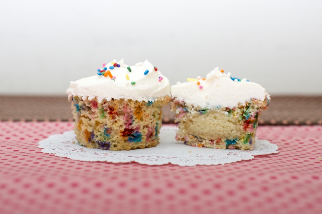 Confetti cupcake with sugar cookie inside topped with vanilla buttercream
