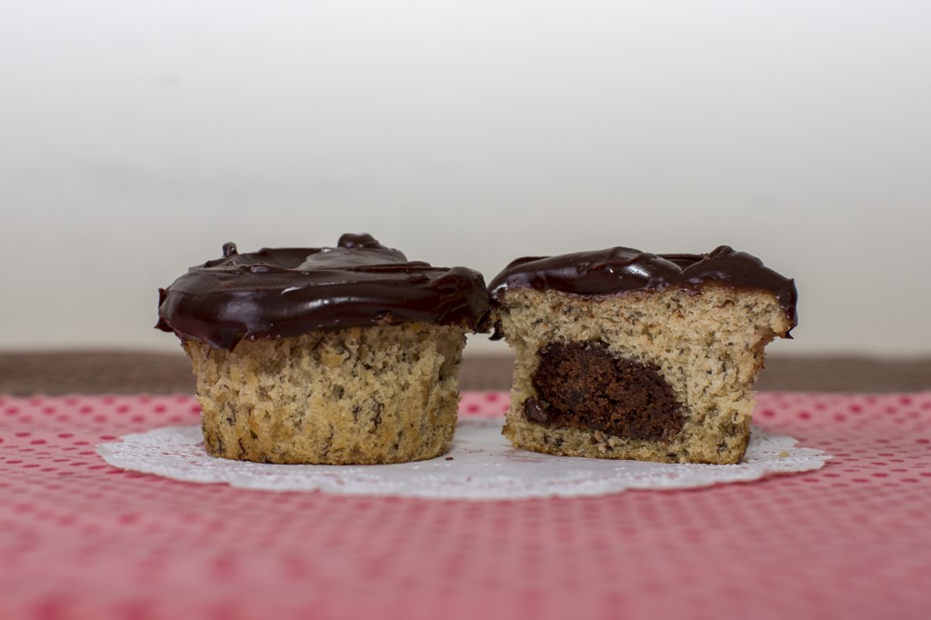 Banana cupcake with chocolate chocolate chip cookie inside topped with fudge frosting