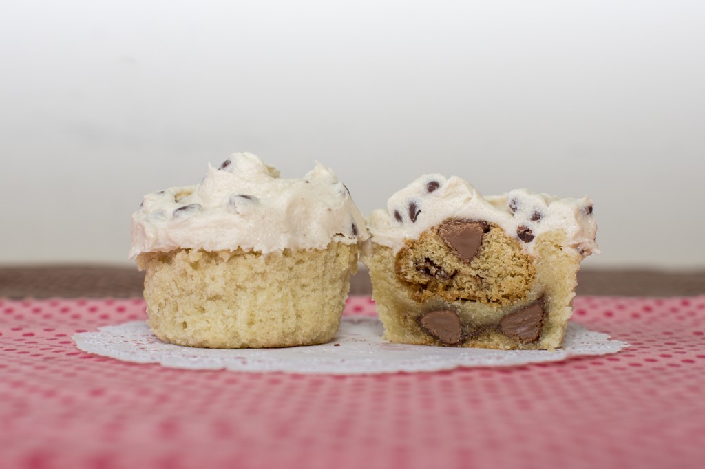 Gluten-Free vanilla cupcake with gluten-free chocolate chip cookie dough inside topped with a gluten-free chocolate chip cookie and gluten-free chocolate chip cookie dough buttercream