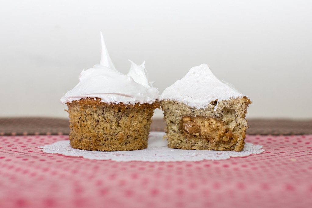 Banana cupcake with peanut butter cookie inside topped with marshmallow frosting